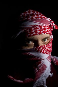 Close-up photograph of a man in a red keffiyeh.