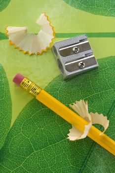 Pencil sharpner and pencil on green texture