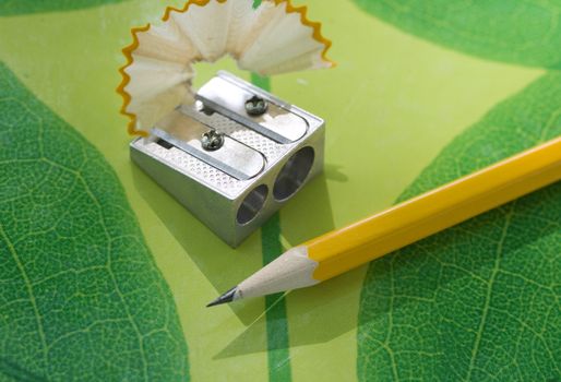 Pencil sharpner and pencil on green texture