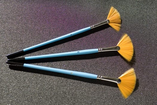 Fan shaped paintbrushes on anthracite background