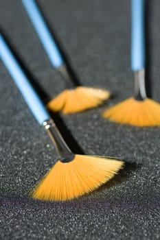 Fan shaped paintbrushes on anthracite background