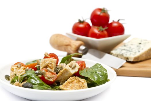 Spinach salad with chopping board of cheese and cherry tomatoes 