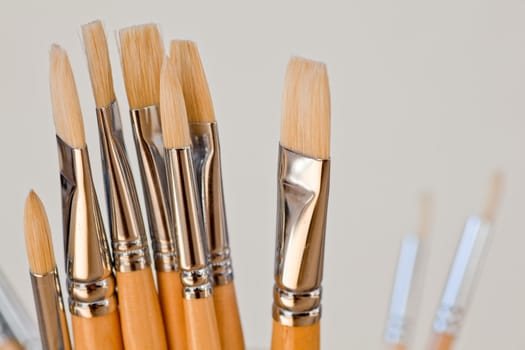 New paintbrushes in a old ceramic jar
