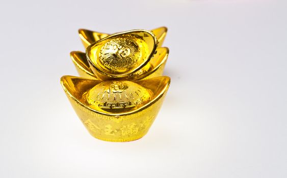 Chinese gold ingots stacking on white surface