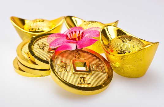 Close up view of Gold ingots and Chinese Emperor's coin  on white surface