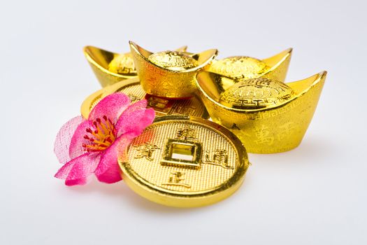 Close up view of Gold ingots of various size and Chinese Emperor's coins  on white surface