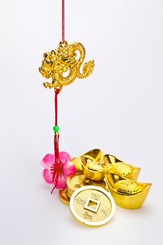 Hanging golden dragon with god ingots and coins against white background