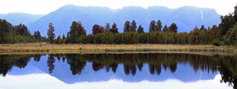 panorama reflection of mount cook at Lake Matheson with cloudy sky in the morning New Zealand