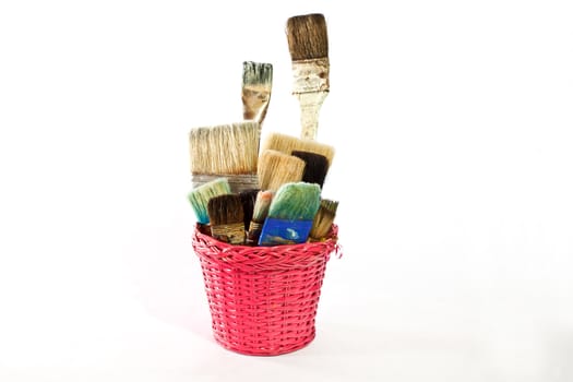 Various used Paintbrushes in a wicker basket