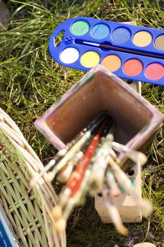 Photo of paintbrushes inside a cup and watercolor