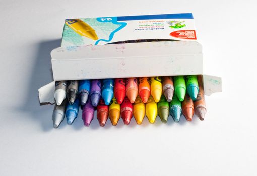 Close up of crayons inside a box, isolated on white background