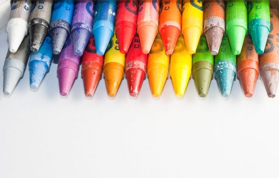 Close up of crayons inside a box, isolated on white background