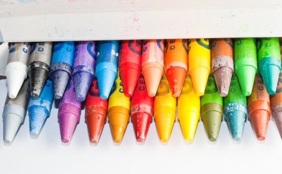 Close up of crayons inside a box, isolated on white background