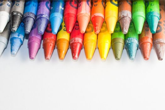 Close up of crayons inside a box, isolated on white background