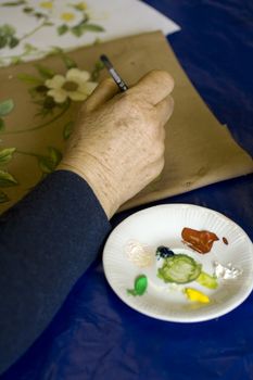 Artist painting flowers on fabric