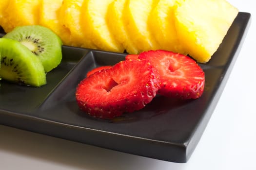 Sliced fruits on black saucer