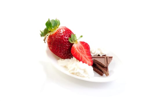 Strawberries cream and chocolate on saucer