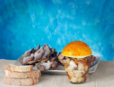Mushrooms inside a jar on a blue background