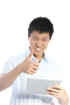Smiling Asian man giving a thumbs up of success and approval with one hand while holding a tablet in the other isolated on white