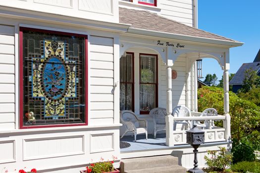 Historical white American house porch with stain glass window. Port Townsend, WA.