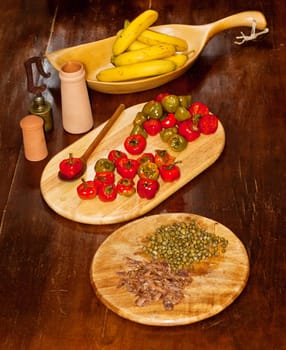 Red hot chili peppers on cutting board, bananas, capers and anchovies