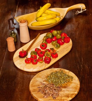 Red hot chili peppers on cutting board, bananas, capers and anchovies