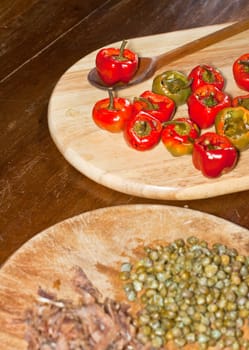 Red hot chili peppers on cutting board, capers and anchovies