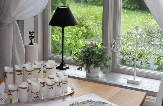 Modern home window with candles and decorations.