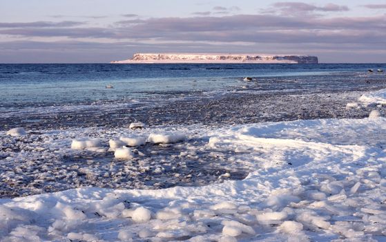 Frozen coastal landscape with island outside.