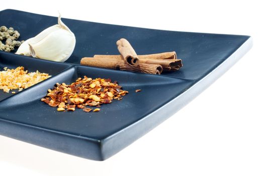 Different Spices on a black saucer