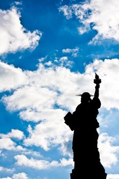Sunnny day, blue sky with clouds: statue of Liberty with copy space