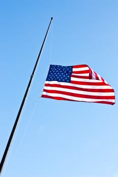 American flag on a blue sky during a windy day