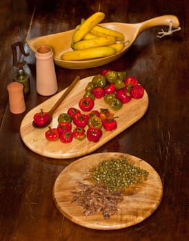 Red hot chili peppers on cutting board, bananas, capers and anchovies