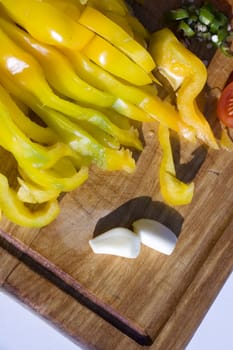 Yellow sliced pepper and garlic on a cutting board