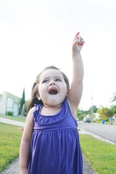 happy little girl three years old signing the sky