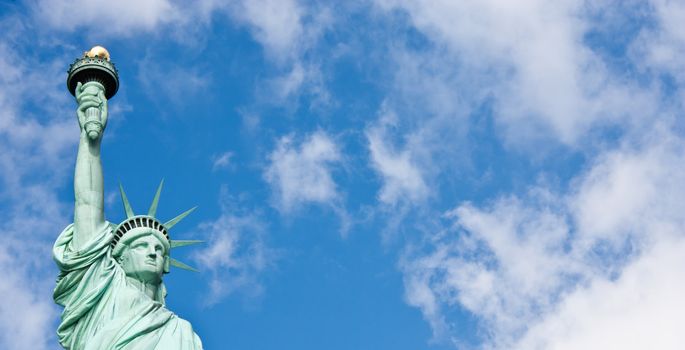 Sunnny day, blue sky with clouds: statue of Liberty with copy space