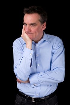 Angry Frowning Middle Age Business Man with Hand to Chin Black Background