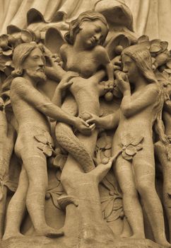 Detail on Notre Dame de Paris Cathedral fachade: Adame, Eve and the forbidden apple