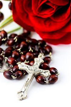 Rosary and rose on a white background