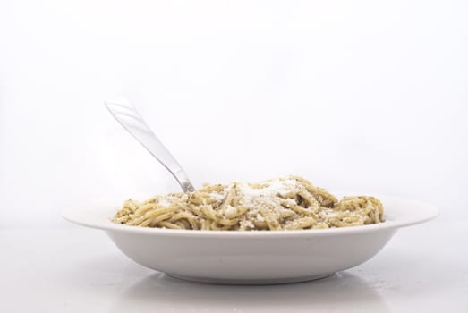 Spaghetti with pesto and cheese isolated on white background