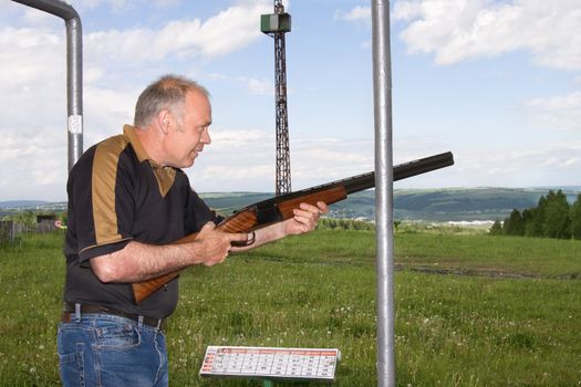 A man shoots a gun on skeet