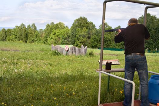 A man shoots a gun on skeet