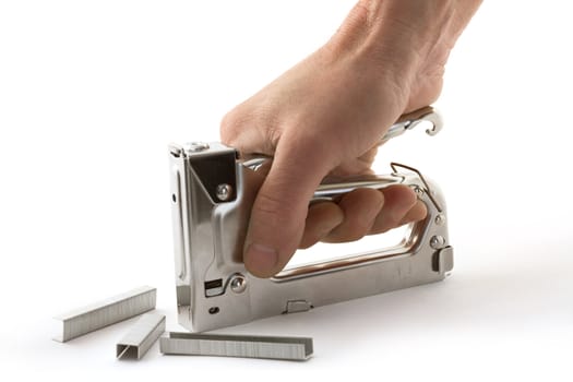 Hand holding a stapler for repair of furniture