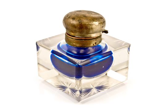 Antique glass inkwell with blue ink isolated on white