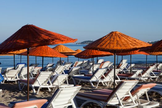 Beach loungers and umbrellas on the sea.