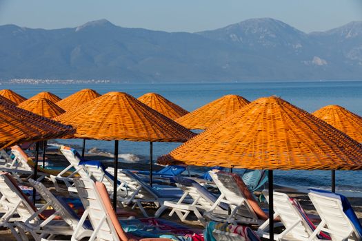 Beach loungers and umbrellas on the sea.