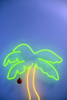 Neon Palm tree with Christmas decoration on blue background