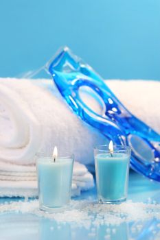 Blue spa relaxation with candles and towels