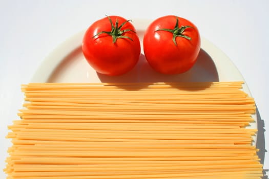 Close up of a pasta and tomatos on a plate.
