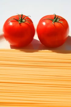 Close up of a pasta and tomatos on a plate.
